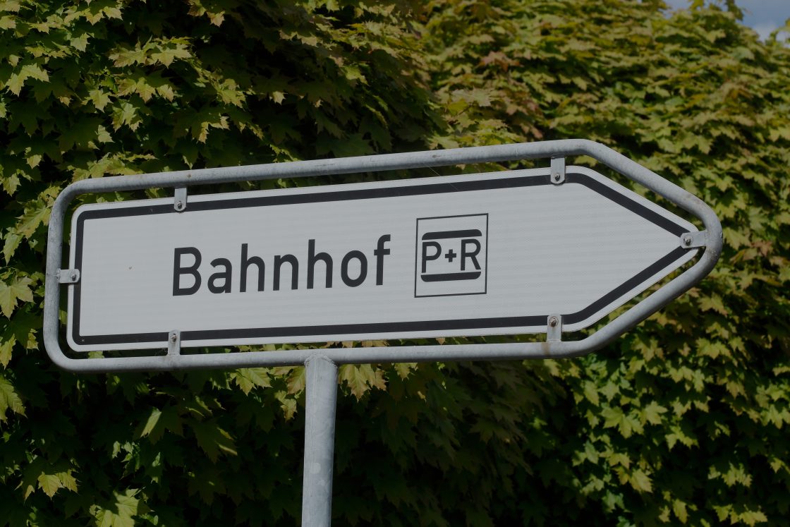 Verkehrsschild, das in Richtung Bahnhof und P+R Möglichkeiten deutet