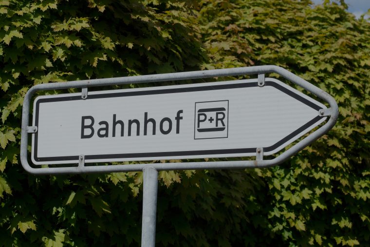 Verkehrsschild, das in Richtung Bahnhof und P+R Möglichkeiten deutet