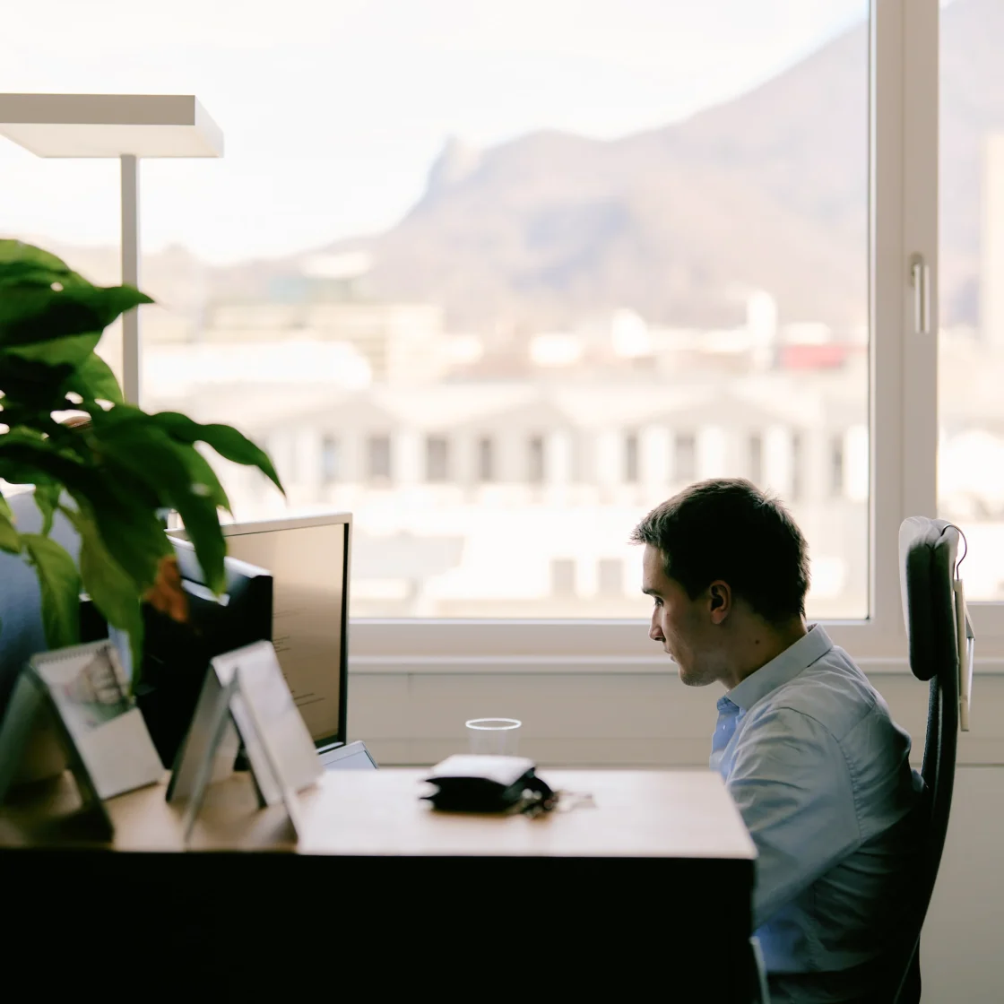 Employee at work, with a blurred view of the city in the background.
